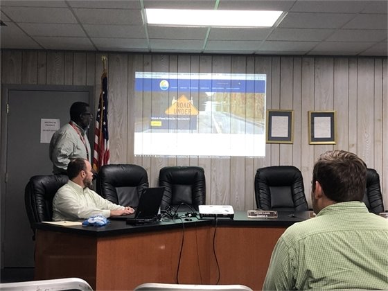 District staff presenting a presentation about the FEMA flood mapping initiative at city hall with a tentative audience.